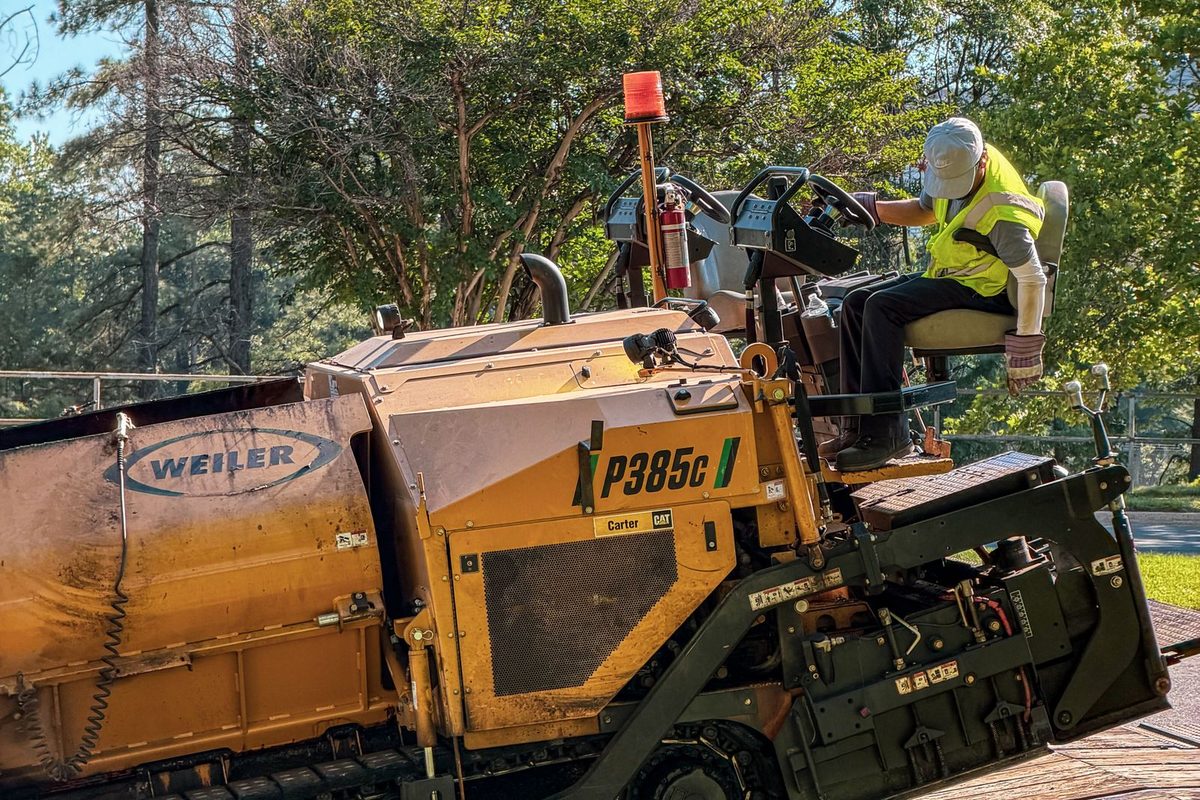 Crew laying and compacting hot asphalt