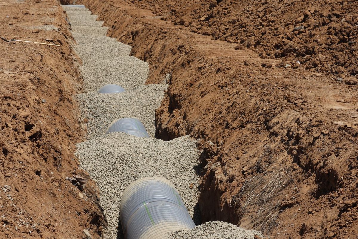 Perforated drainage pipe laid in gravel to carry water away from the foundation