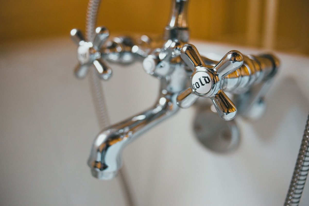 Close-up of a vintage chrome faucet on a white bathtub in Anchorage, AK