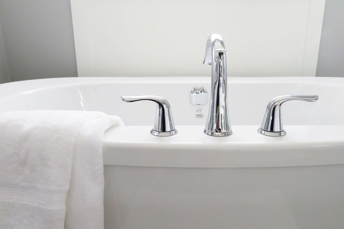 A clean white bathtub with chrome fixtures in a Anchorage, AK bathroom