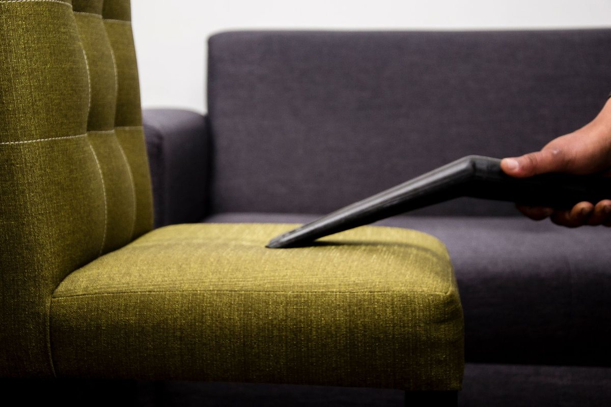 Vacuuming upholstery on a sofa in Anchorage