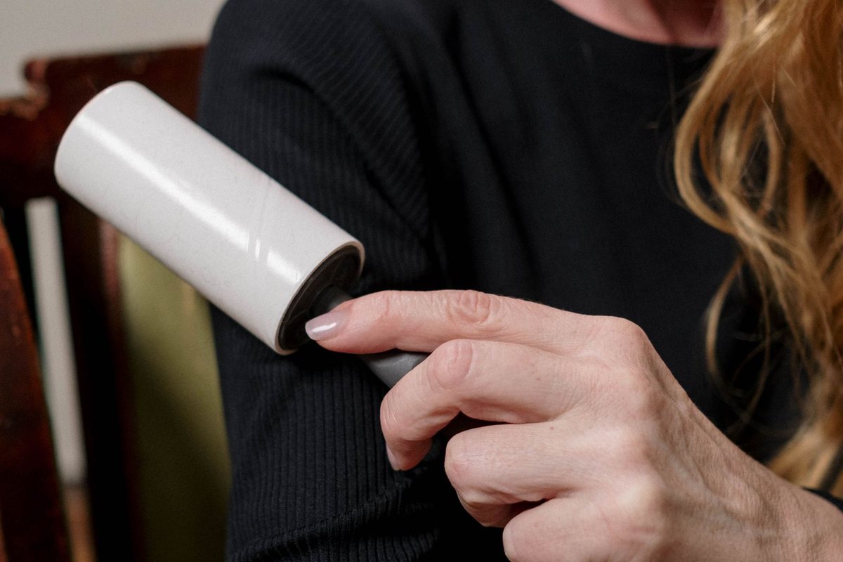 A lint roller lifting lint from a fabric surface