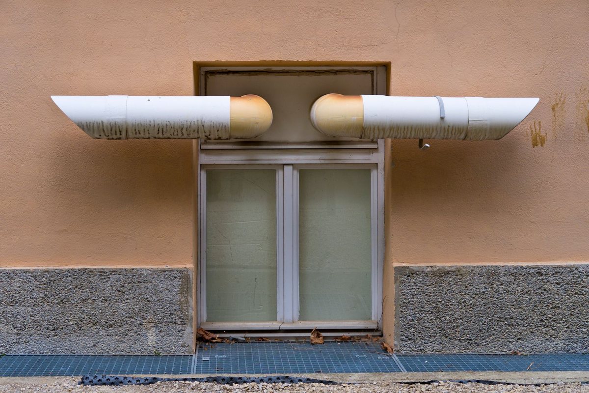 Exterior ventilation pipes on a building wall