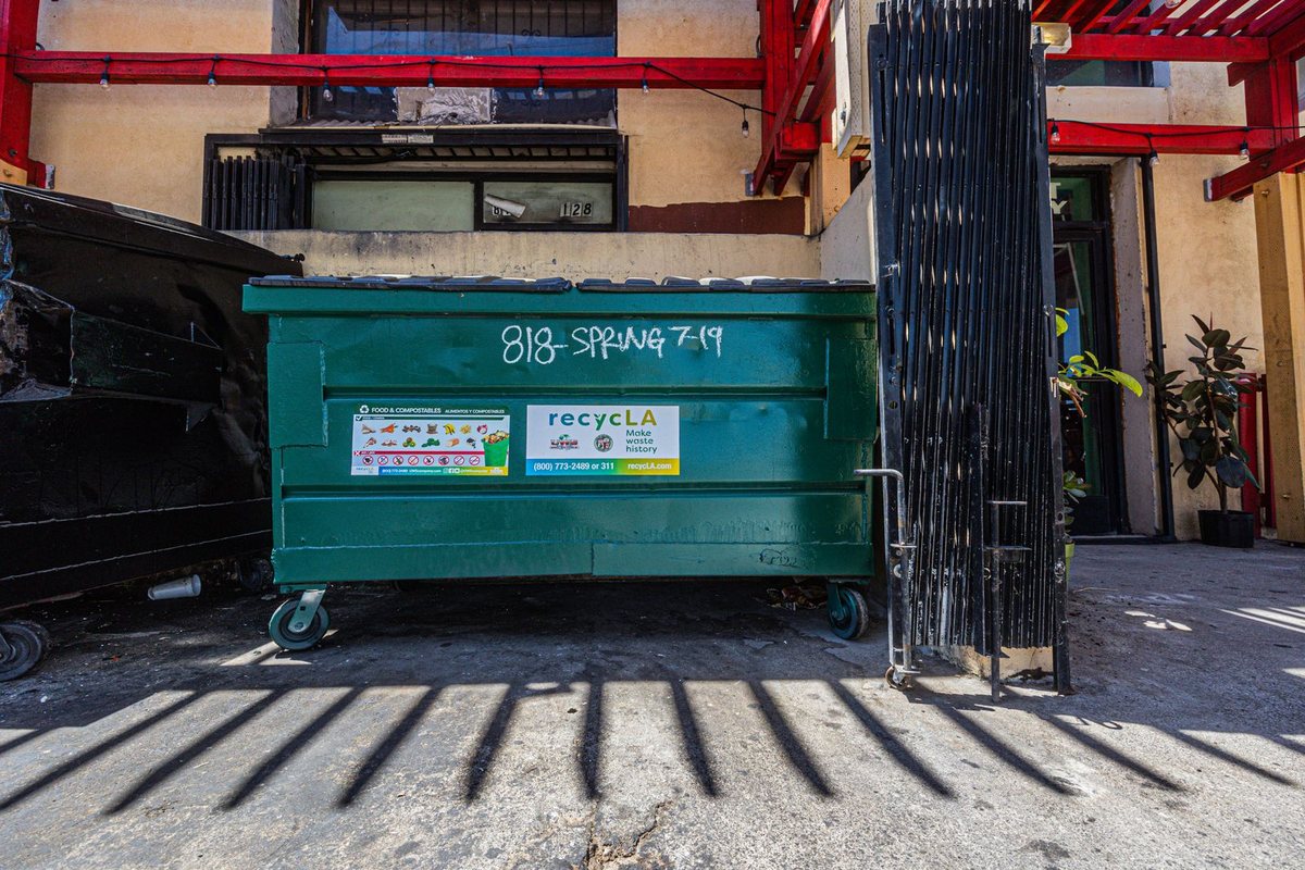Waste dumpster positioned behind a commercial building in Anchorage, AK