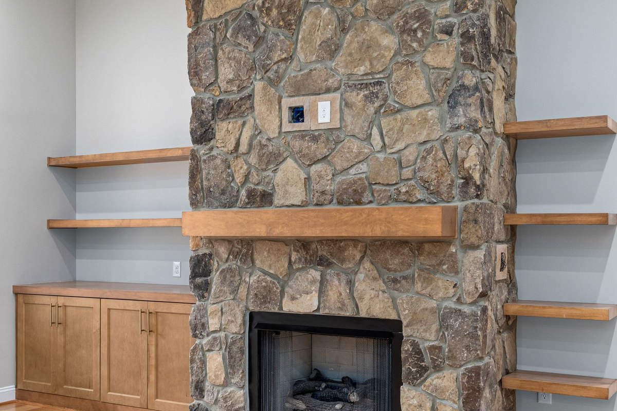 Stone fireplace with a mantel in a Anchorage, AK living room