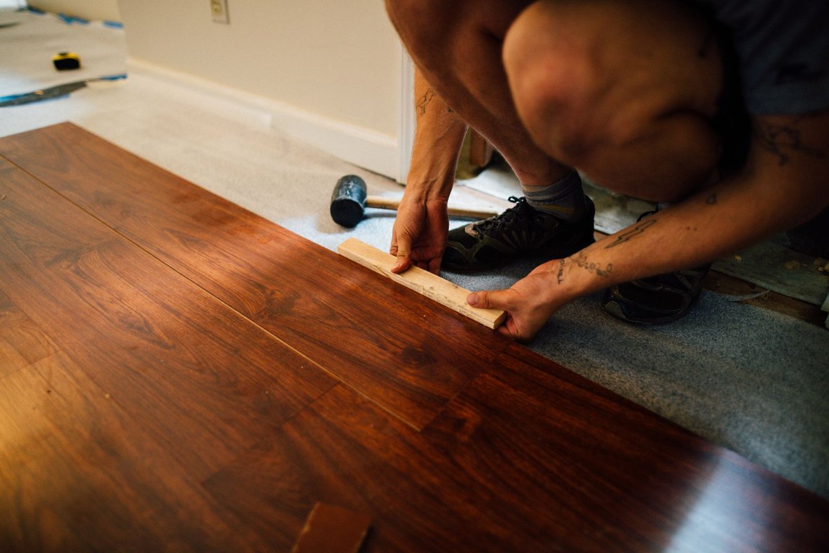 New flooring being installed plank by plank in a Anchorage, AK home