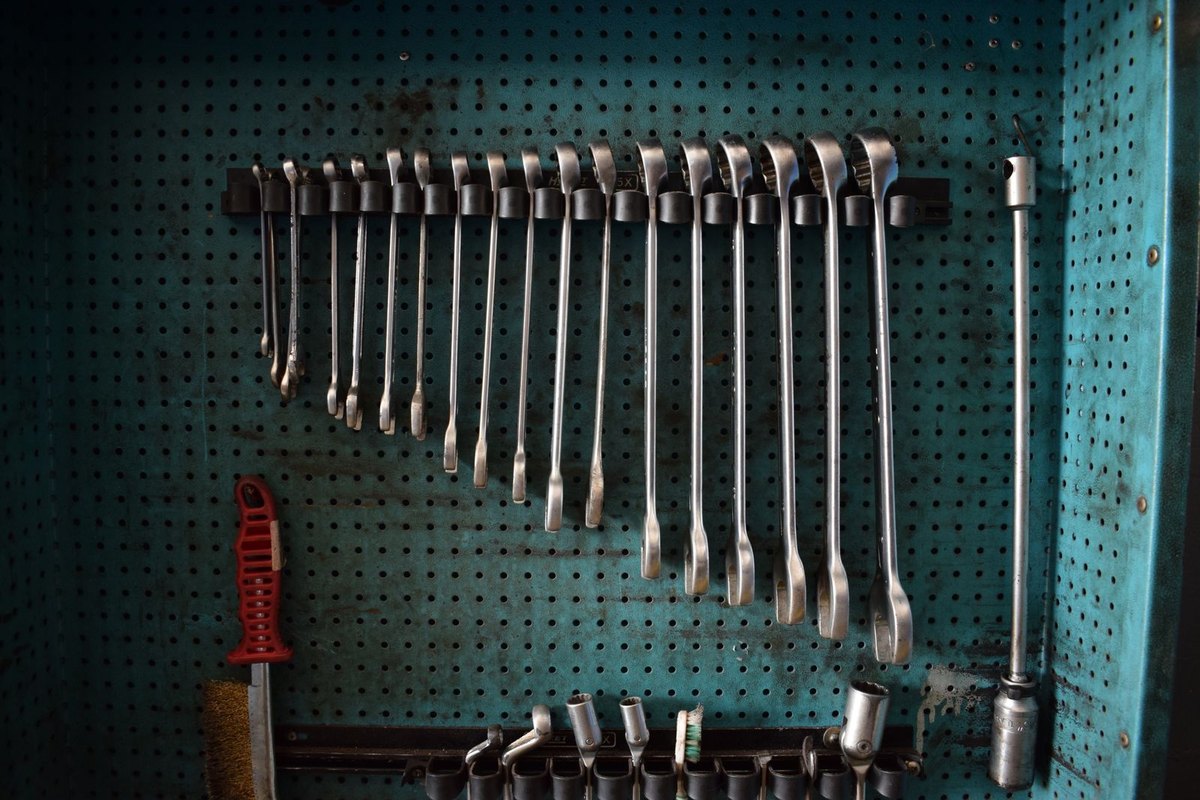 A pegboard wall with wrenches hung in order — wall-mounted tool organization
