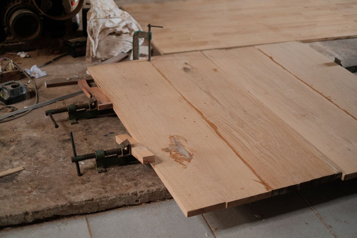 Wooden floor boards clamped during prep in a workshop