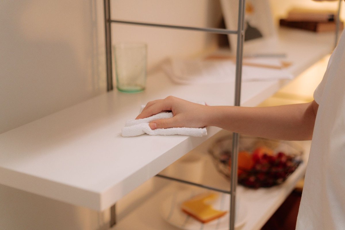 Cleaner wiping and refreshing a tidy living space in Anchorage