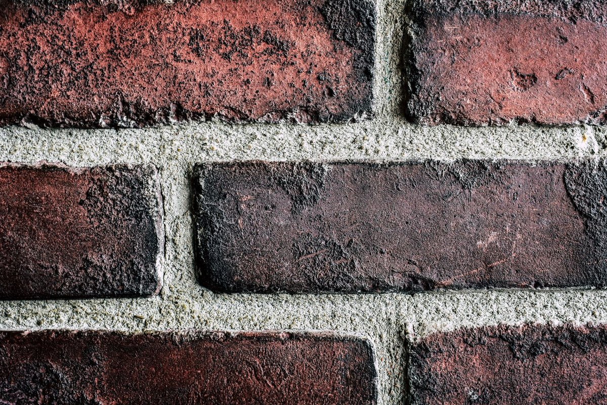 Fresh mortar packed into ground-out brick joints during tuckpointing