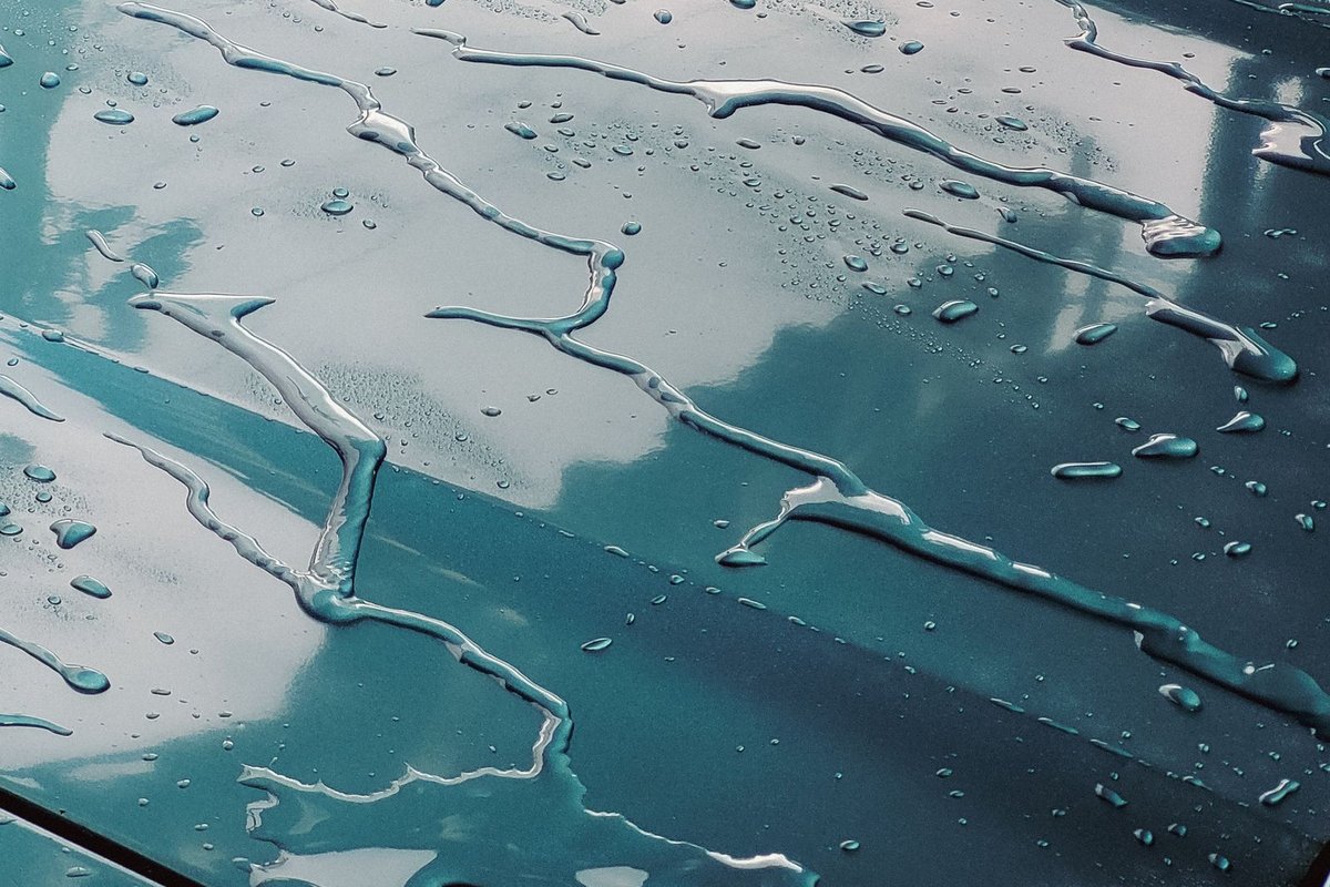 Glossy ceramic-coated car paint beading water in Anchorage