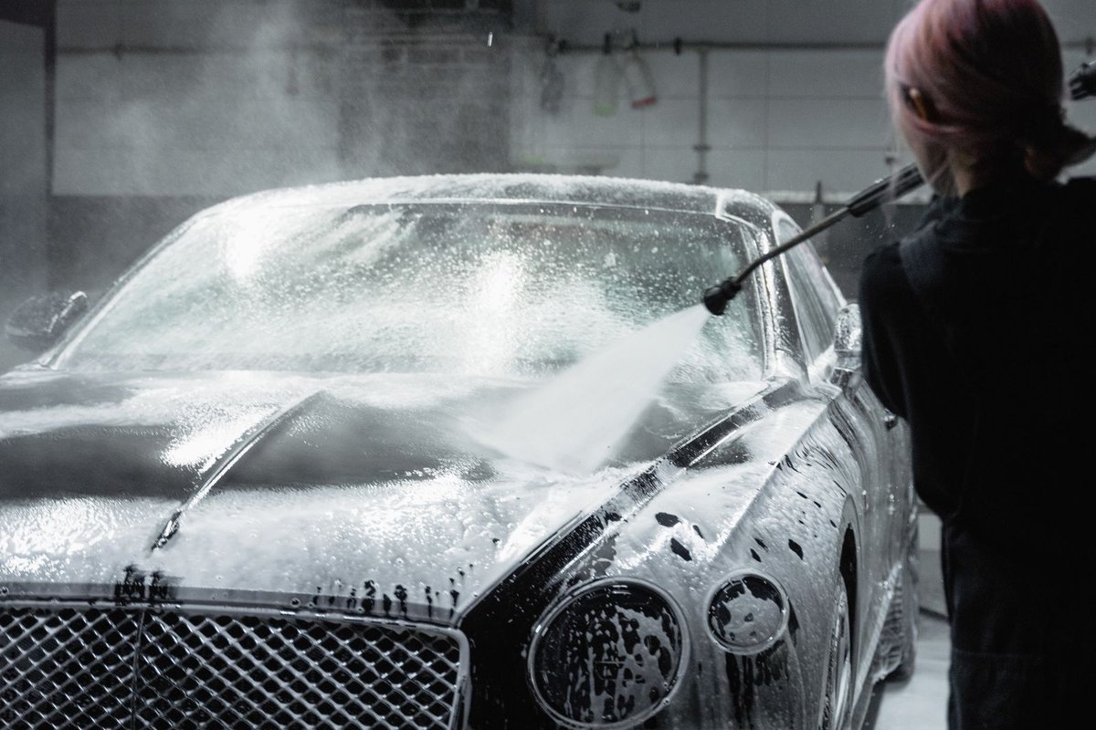 Mobile detailer hand washing a car exterior in Anchorage, AK