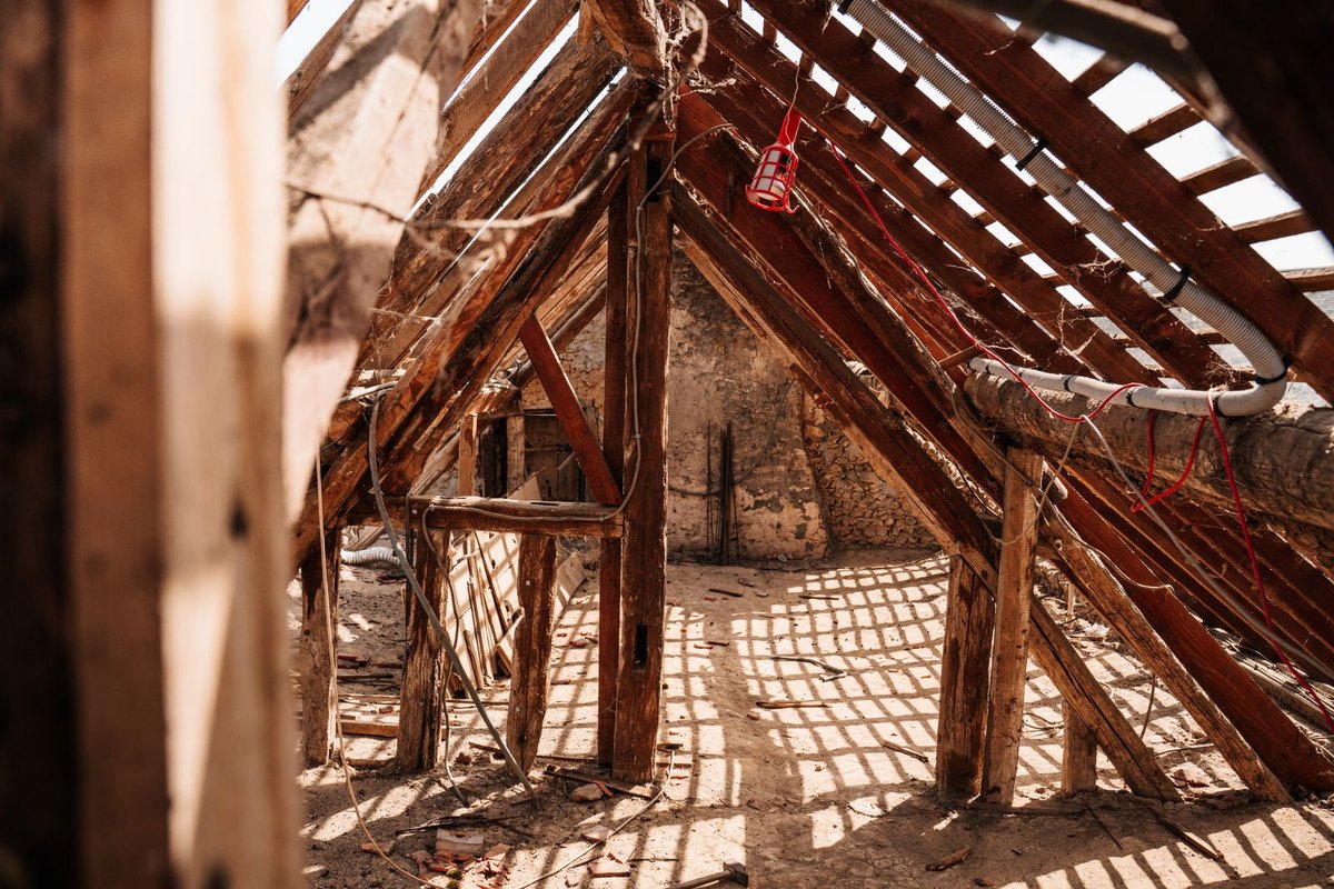 Exposed wooden rafters and trusses inside an attic