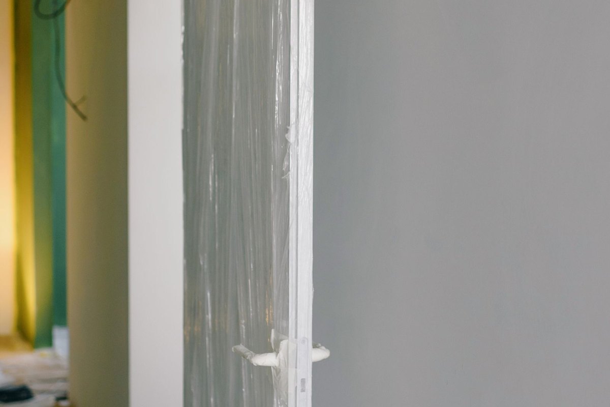 Doorway draped with plastic sheeting in an empty room