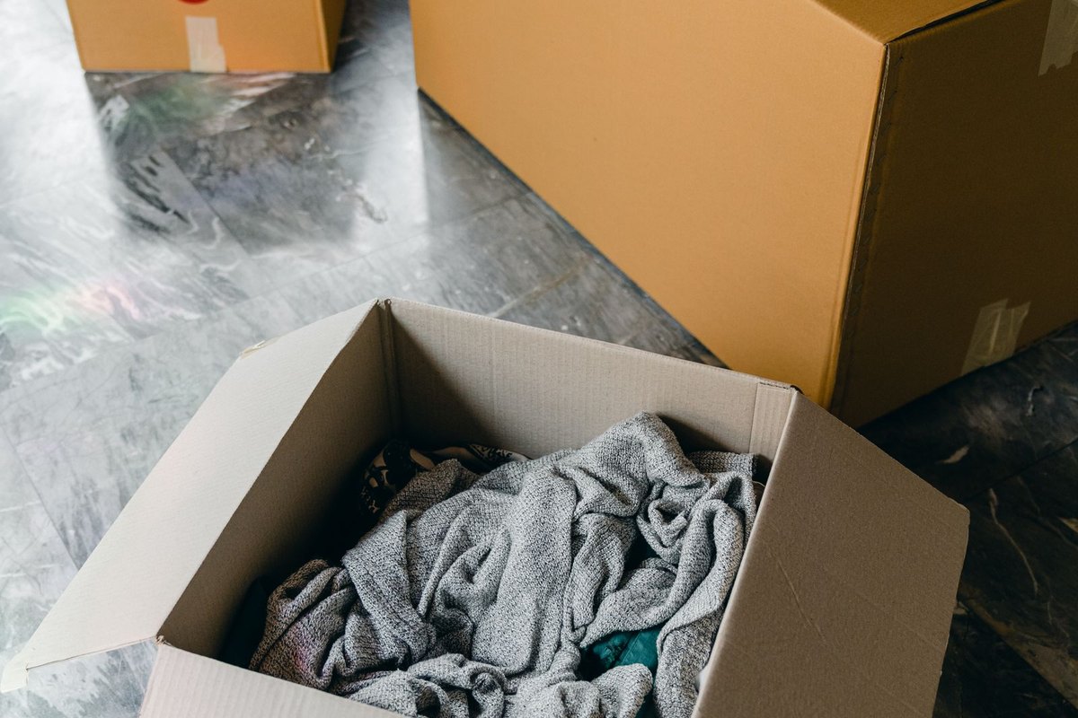 An open moving box packed with household belongings in Anchorage