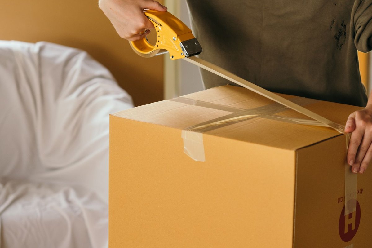 Sealing a cardboard moving box with packing tape
