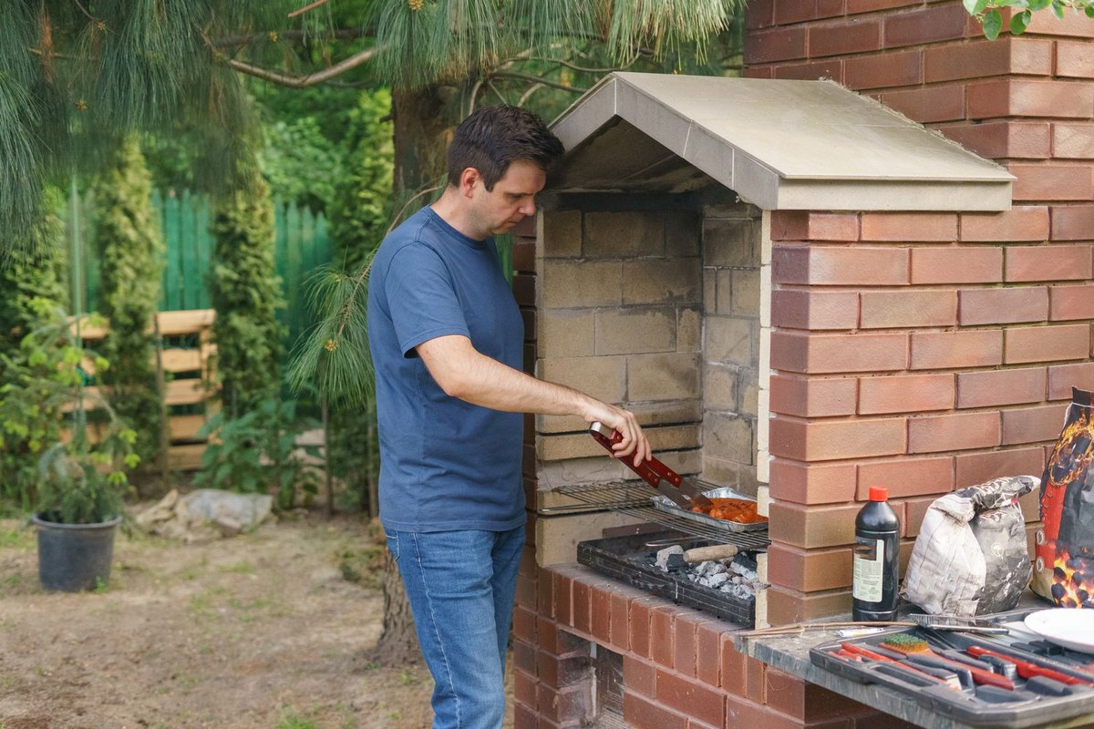 A built-in brick barbecue grill in a backyard garden