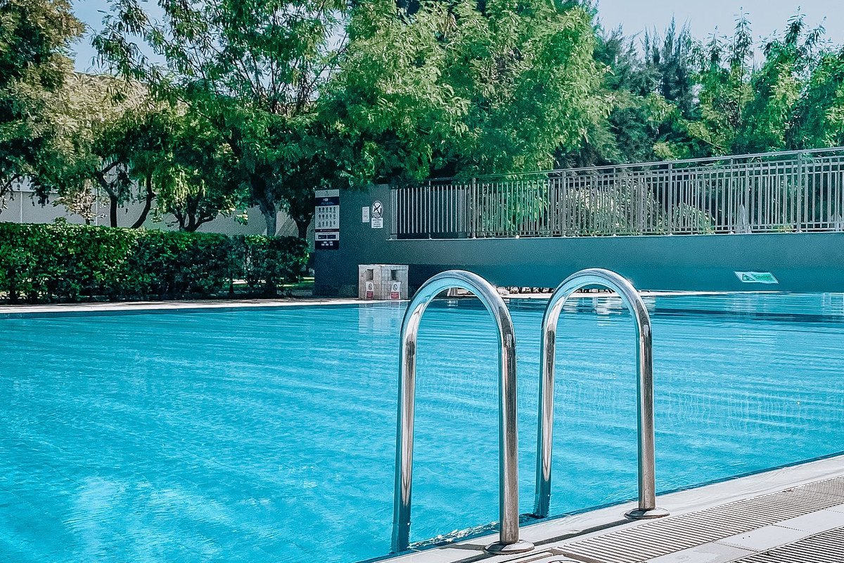 Finished concrete pool with railings and safety fencing in a Anchorage backyard