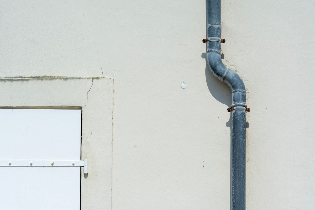 Metal pipe running down the exterior wall of a building