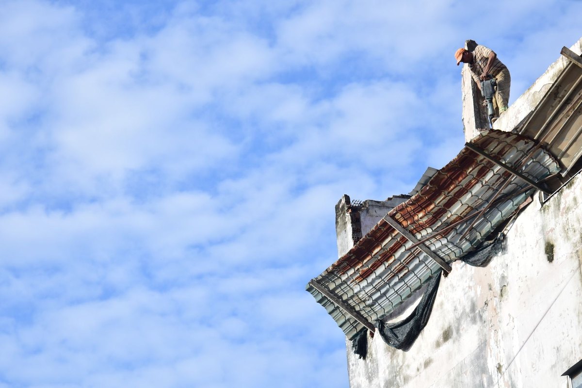 Worker on the edge of a building roof under a clear sky