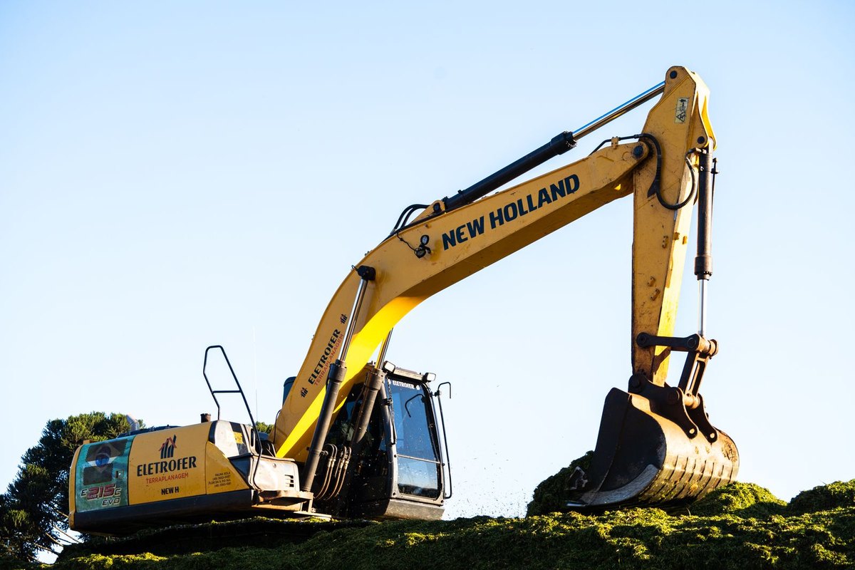 A yellow excavator, the kind of machine used to open the ground for a sewer line replacement in Anchorage, AK