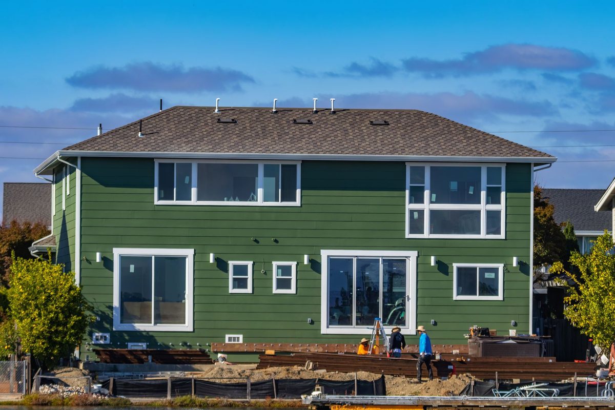 Workers on site during exterior siding work on a Anchorage home