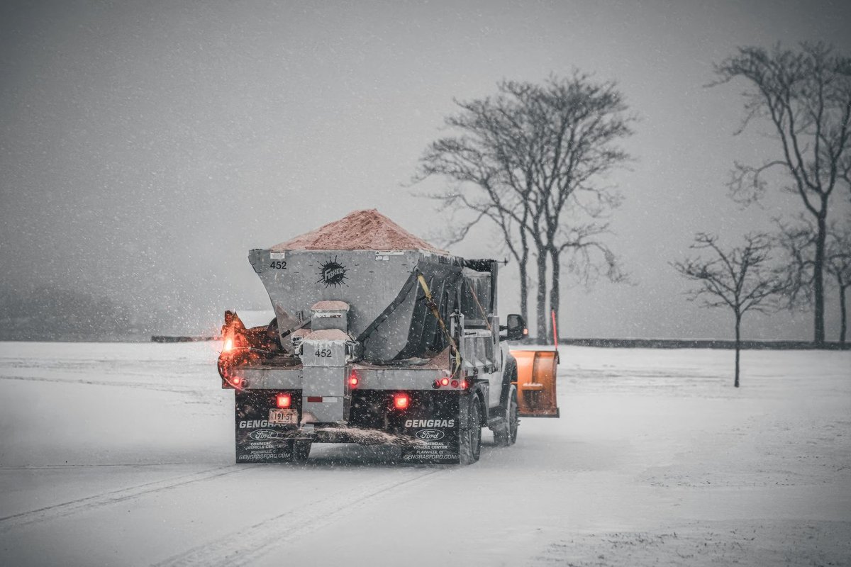 Salt spreader truck de-icing a snow-covered road
