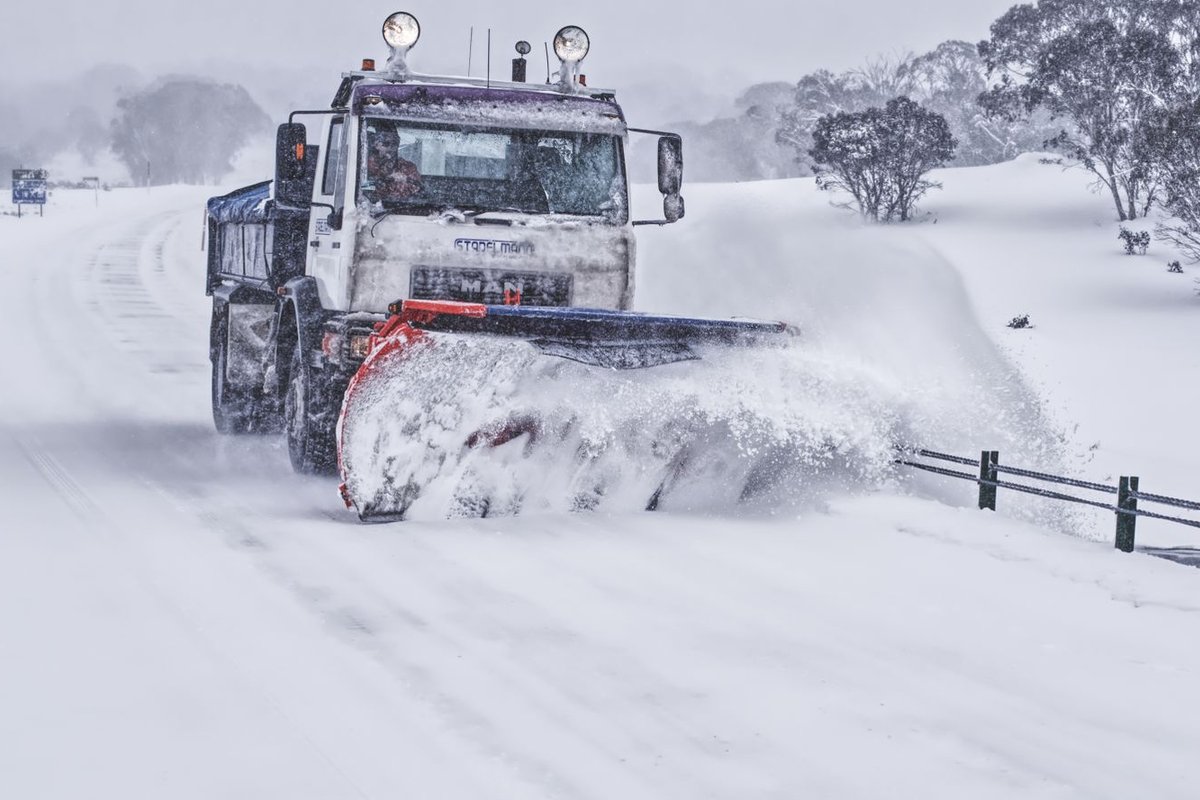 Snow plow truck clearing a snow-covered surface
