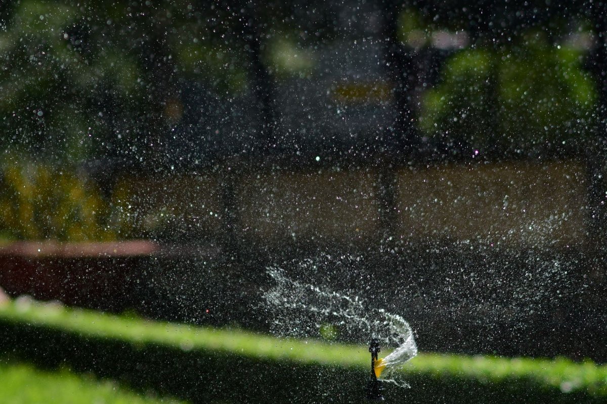 An automatic sprinkler system watering a lawn on its set schedule in Anchorage, AK