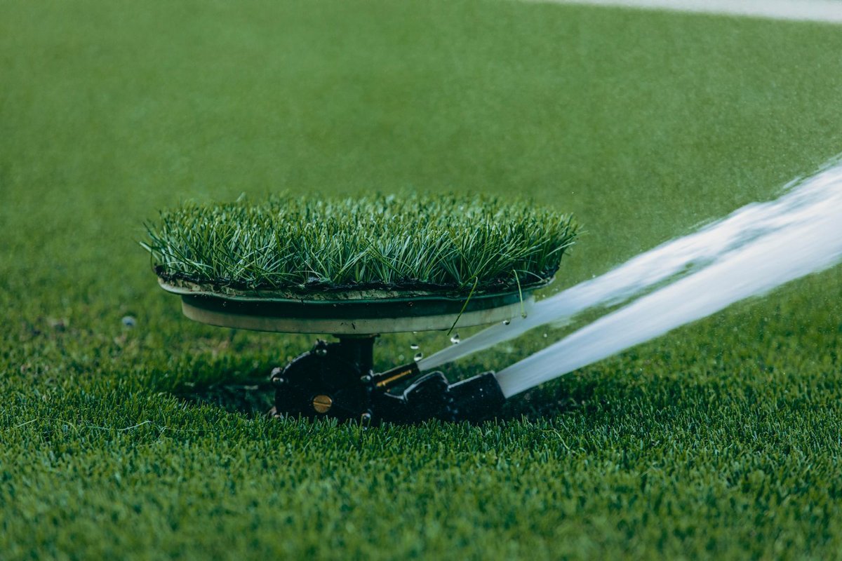 Pop-up sprinkler head watering a green lawn in Anchorage, AK
