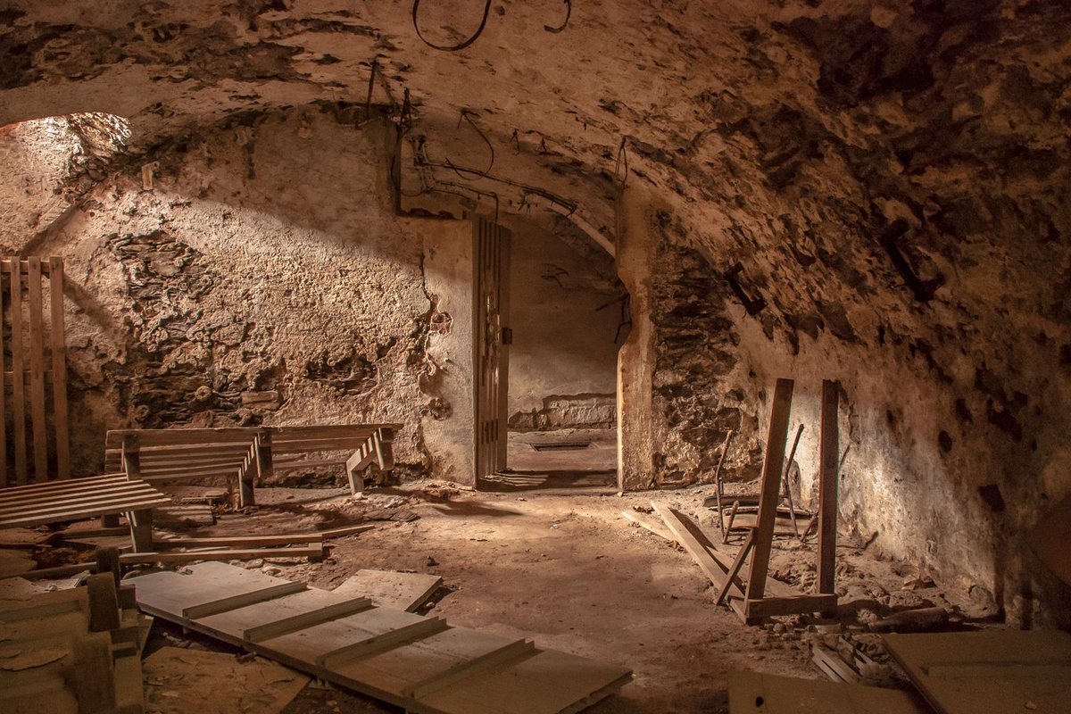 An old, unfinished basement with bare stone walls