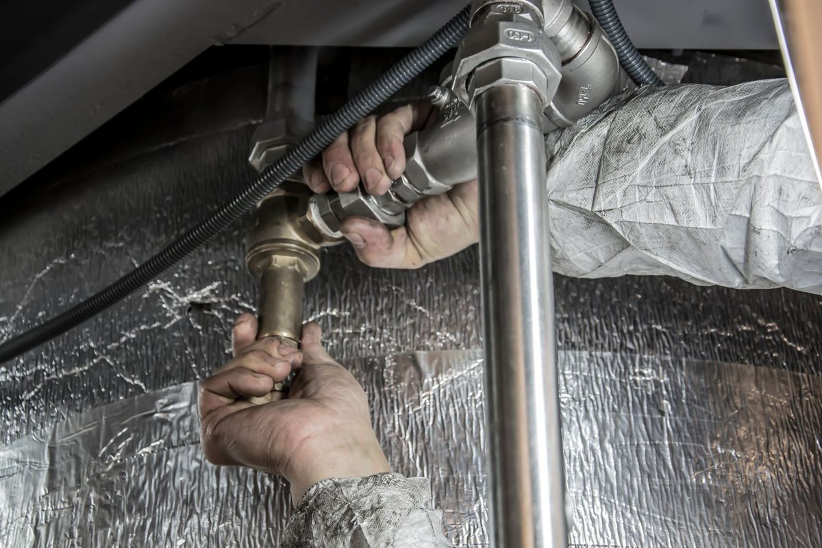 Plumber working on water supply pipes