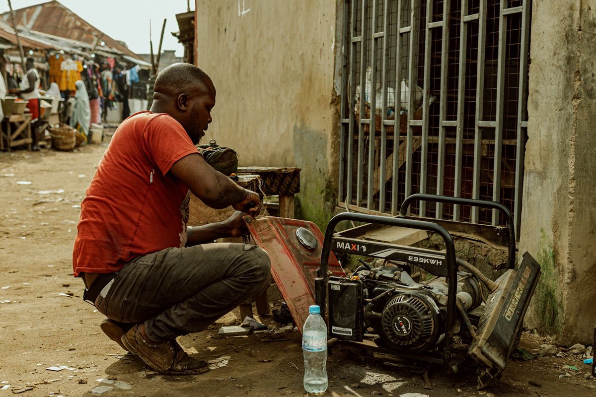 A worker repairing a generator outdoors in Anchorage, AK